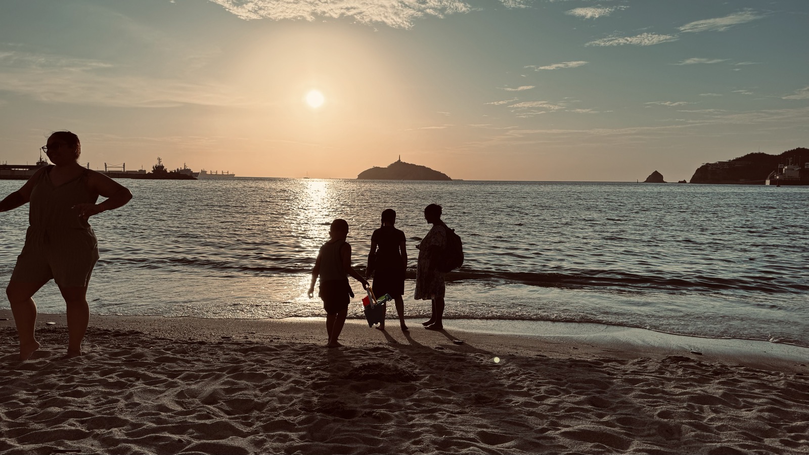 Children playing on the beach at sunset