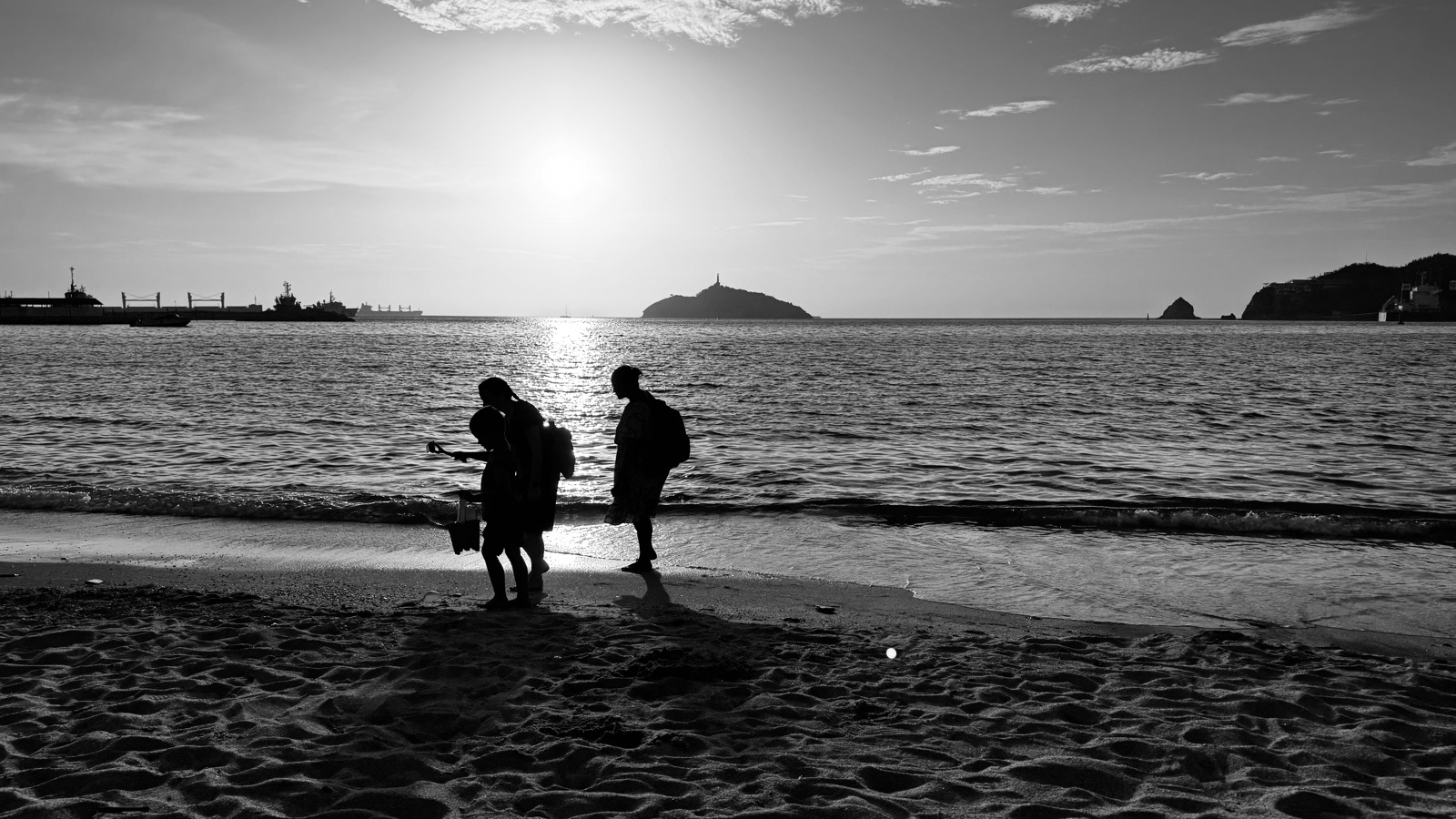 Family silhouettes on the beach at sunset
