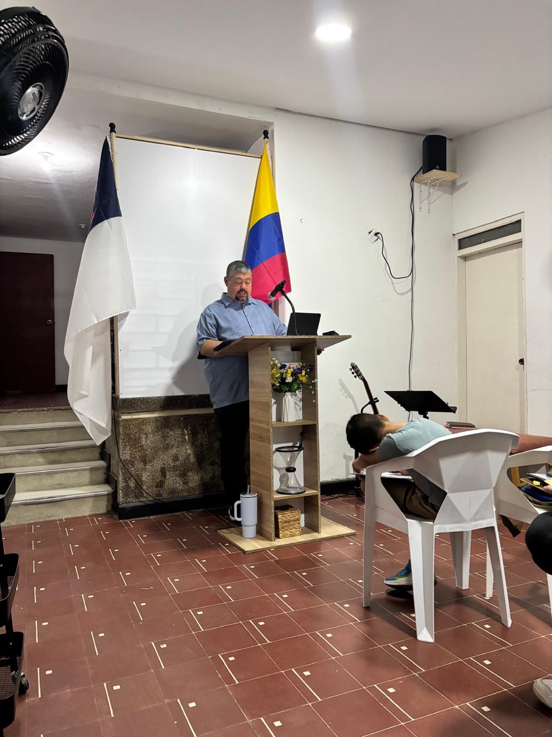 Preaching from the pulpit with the Colombian flag displayed